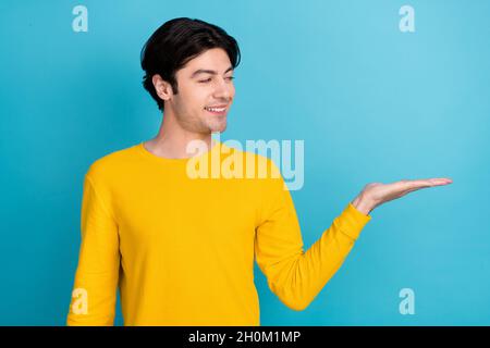 Foto Porträt Mann suchen Copyspace halten auf Händen isoliert pastellblauen Hintergrund Stockfoto