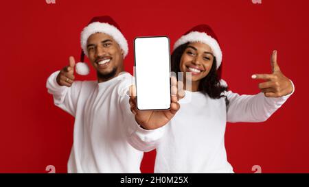 Positive afroamerikanische Liebhaber zeigen Handy mit leerem Display Stockfoto