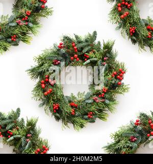 Nahtloses Muster von dekorativem Weihnachtskranz auf weißem Hintergrund. Frohe weihnachten Grußkarte. Traditionelle Dekoration für Winterferien. Stockfoto