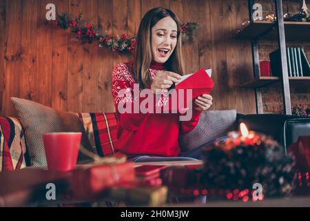 Foto von süß beeindruckt reifen Dame tragen roten Pullover lächelnd immer weihnachten Glückwünsche im Haus Heim Zimmer Stockfoto