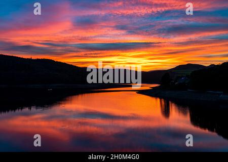 Dramatischer, farbenfroher Sonnenuntergang über dem Ladybower Reservoir im Upper Derwent Valley im Peak District, Derbyshire, Großbritannien Stockfoto