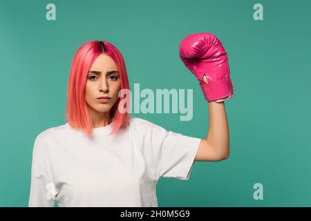 Junge Frau mit rosa gefärbten Haaren in Boxhandschuh isoliert auf blau Stockfoto