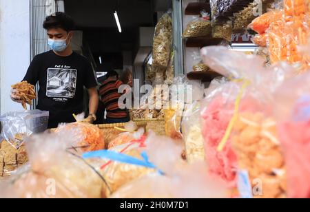 Bandung, Indonesien-September 29,2021: Snack-Händler stecken gebratenen Tempeh in eine Plastiktüte Stockfoto