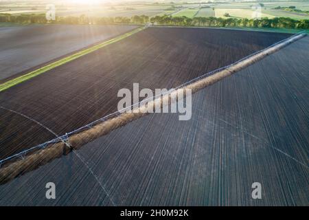 Luftbild des mittleren Schwenk-Bewässerungssystems, das im Frühjahr auf einem runden Feld arbeitet Stockfoto