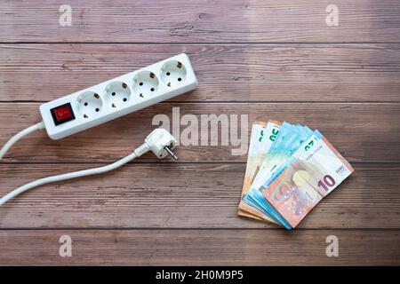 Weiße elektrische Steckdosenleiste für den Haushalt mit Netzschalter und einem Paket von Rechnungen Stockfoto