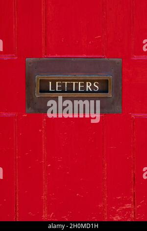 Briefkasten mit Buchstaben an der roten Tür - UK Stockfoto