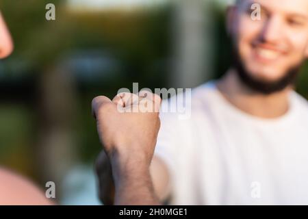 Nahaufnahme von zwei Männern, die mit den Fäusten zusammenprallen Stockfoto