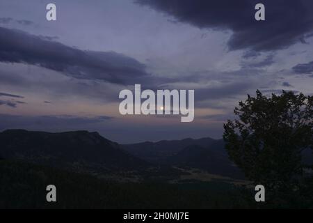Der Mond steigt nach Sonnenuntergang über dem Rocky Mountain National Park auf Stockfoto