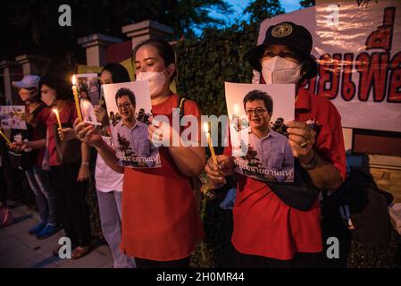 Bangkok, Thailand. Oktober 2021. Demonstranten zünden eine Kerze an und zeigen ein Porträt von Anon Nampa, einem Aktivisten, der während der Demonstration durch das Gesetz von Lese majeste festgenommen wurde.Anti-Regierungsgegner versammelten sich vor dem Bangkok-Untersuchungsgefängnis in Bangkok und forderten die Freilassung politischer Gefangener, die durch das Gesetz von Lese majeste festgenommen wurden (Artikel 112 des thailändischen Strafgesetzbuches), Abschaffung des Artikels 112 (Gesetz von Lese majeste), Reform der Monarchie und Rücktritt von Prayut Chan-O-Cha. Kredit: SOPA Images Limited/Alamy Live Nachrichten Stockfoto