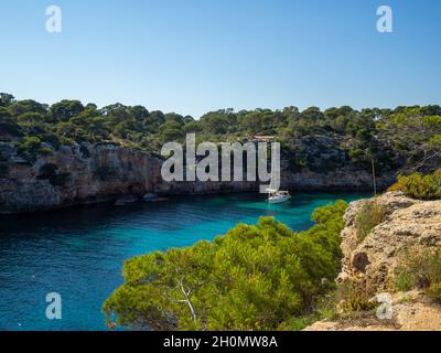 Ein Segelboot, das im türkisfarbenen Wasser von Cala Pi, Maiorca, schwimmt Stockfoto