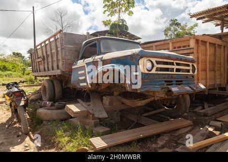 Pilcopata, Peru - 12. April 2014: In einer der Straßen von Pilcopata ruht ein alter, rostiger und verlassener Lastwagen, der halb verschrottet wurde Stockfoto