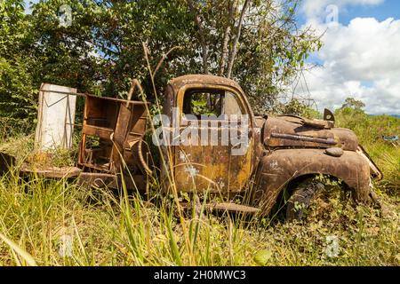 Pilcopata, Peru - 12. April 2014: In der Umgebung von Pilcopata ruht ein alter Ford-LKW, verrostet und verlassen, umgeben von Unkraut Stockfoto