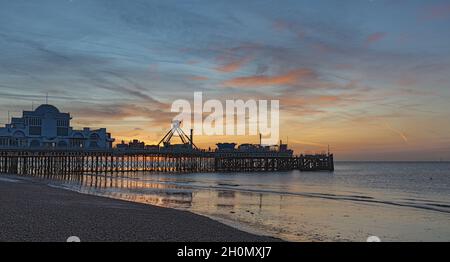 South Parade Pier am Southsea Beach bei Sonnenaufgang bei Ebbe und blauem Himmel Stockfoto