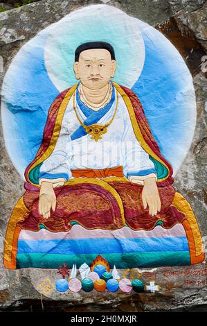 Ein farbenfrohes Felsgemälde von Marpa (aus der buddhistischen Religion) auf einem Felsen auf der Heiligen Insel, vor der Insel Arran, Schottland. Stockfoto