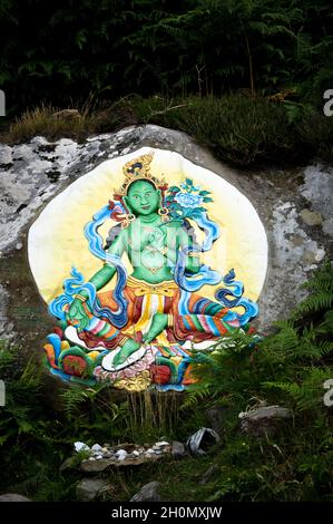 Ein farbenfrohes Felsgemälde von Green Tara (aus der buddhistischen Religion) auf einem Felsen auf der Heiligen Insel, vor der Insel Arran, Schottland. Stockfoto