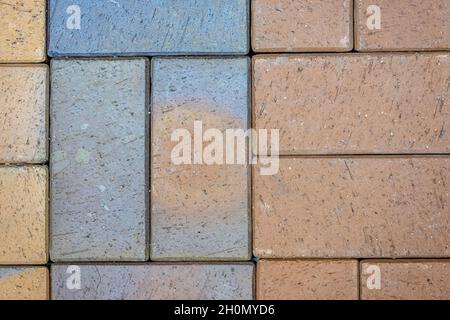 Nahaufnahme einer grauen und roten zerkratzten Pflasterplatte Stockfoto