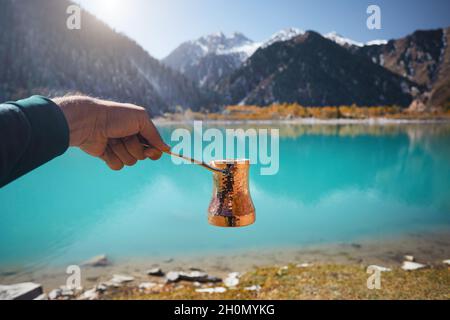 Kupfer Cezve für Kaffee im Herbst See Camping in den Bergen. Zubereitung von Kaffee im Freien Konzept Stockfoto