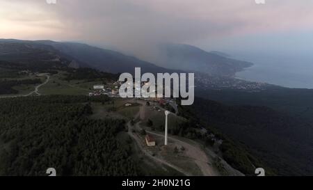 Bucht des Meeres, Berge, Felsen, Böschung und Stadtgebäude bei Sonnenuntergang Luftaufnahme. Aufnahme. Luftaufnahme des Sonnenuntergangs. Luftaufnahme von erstaunlichen Bergen und Stockfoto