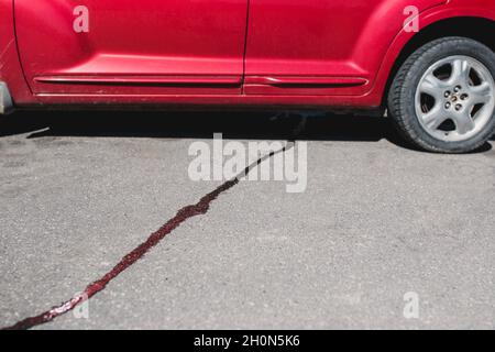 Kraftstoffleck unter dem Fahrzeug - Flecken auf dem Bürgersteig Stockfoto