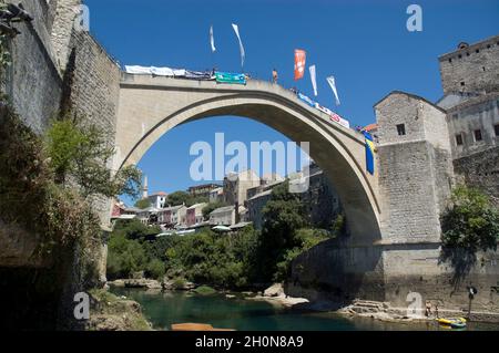 Ein Mann steht auf der Alten Brücke, bevor er springt - die Stadt Mostar in Bosnien und Herzegowina - Blick auf Stari Most, alte osmanische Brücke, die die überquert Stockfoto