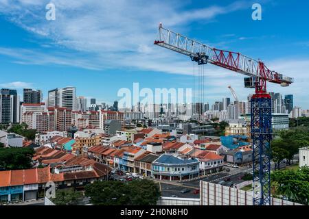 SINGAPUR, SINGAPUR - 11. Okt 2021: Kran auf HDB Kontraktionsstelle gegen Singapur Stadtbild an einem sonnigen Morgen. Horizontale Aufnahme Stockfoto