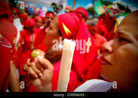 TANZENDE TEUFEL VON YARE..die tanzenden Teufel von Yare ist ein religiöses Fest in der Stadt San Francisco de Yare im Bundesstaat Miranda, Venezuela... Oder 60 Tage nach Ostern kleiden sich Männer aus Yare in roten Gewändern, Umhängen und Masken grotesker Dämonen und tanzen auf den Straßen im Rhythmus von Trommelschlägen und Maracas. Sie schmücken ihre Kostüme mit Scapulars, Rosenkränzen, Kreuzen und anderen religiösen Gegenständen...nach dem Tanzen versammeln sich die Teufel in der historischen katholischen Kirche von San Francisco und knien schweigend, bevor sie von einem Priester gesegnet werden. Das Knien symbolisiert Respekt und ihre Stockfoto