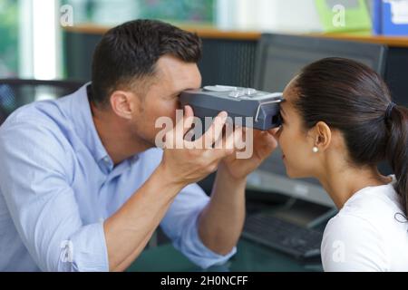 Augenarzt, der den Augeninnendruck einer jungen Frau in der Klinik misst Stockfoto