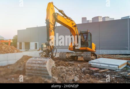 Gelber Bagger auf der Baustelle beschäftigt. Stockfoto