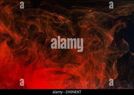 Rote Acrylfarbe spritzt im Wasser auf schwarzem Hintergrund. Minimaler abstrakter Hintergrund. Stockfoto