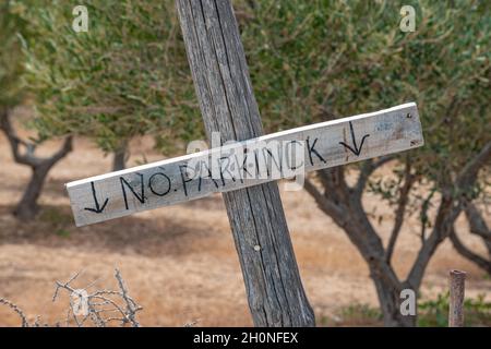 Kein Parkplatz, Schild auf Holzplanke auf Baumhintergrund. Stockfoto