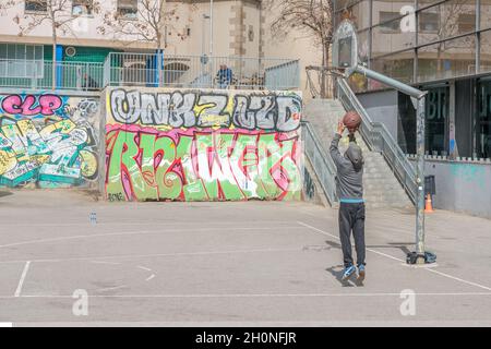 Barcelona, Spanien - 17. März 2019: Junge spielt auf der Straße Basketball. Stockfoto