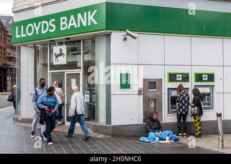 Obdachloser Mann, der vor Lloyds Bank, Church Street, Liverpool, Merseyside, Großbritannien, bettelt. Stockfoto