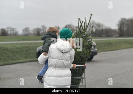 Mutter kaufte einen Weihnachtsbaum auf dem Markt Stockfoto