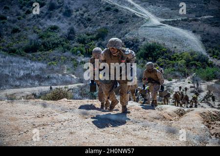 US Marine Corps rekrutiert bei Charlie Company, 1. Rekrut Training Bataillon, einen Hügel hochlaufen während des Tiegels im Marine Corps Base Camp Pendleton, Kalifornien, 12. Oktober 2021. Rekruten trugen Munitionsdosen den Hügel hinauf, um eine Nachversorgung zu simulieren. Der Schmelztiegel war eine 54-stündige Feldtrainingsübung, die kontinuierliche körperliche und geistige Herausforderungen darstellte. (USA Marine Corps Foto von CPL. Grace J. Kindred) Stockfoto