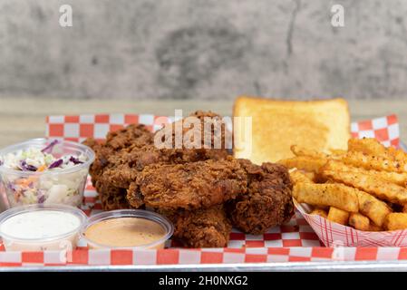 Würzige, heiße Hähnchenflügel mit pommes Frites, cole Slaw, Toast und zwei Dipping-Soßen. Stockfoto