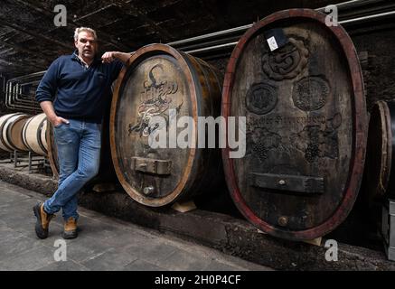 Rech, Deutschland. Oktober 2021. Winzer Alexander Stodden steht im Weinkeller seines Weingutes in Rech neben historischen Eichenholzfässern. (Zu dpa-Bericht „drei Monate nach der Flut im Ahrtal: Sorgen um die Zukunft statt Geld“ von 14.10.2021) Quelle: Boris Roessler/dpa/Alamy Live News Stockfoto