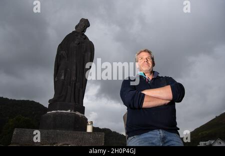 Rech, Deutschland. Oktober 2021. Der Winzer Alexander Stodden steht auf der zerstörten Ahrbrücke in Rech neben einer Basaltskulptur des Hl. Nepomuk. Auf der Basis der Figur steht 'vor großer Zunge und Wasserghrt St. Nepomuk uns immer wahr'. (Zu dpa-Bericht „drei Monate nach der Flut im Ahrtal: Sorgen um die Zukunft statt Geld“ von 14.10.2021) Quelle: Boris Roessler/dpa/Alamy Live News Stockfoto