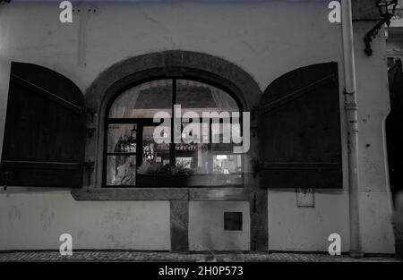 Prag Tschechische Republik - August 29 2017; Blick durch das offene Fenster auf den Mann im Restaurant und die gespenstische verschwommene Gestalt einer vorbeifahrenden Person Stockfoto