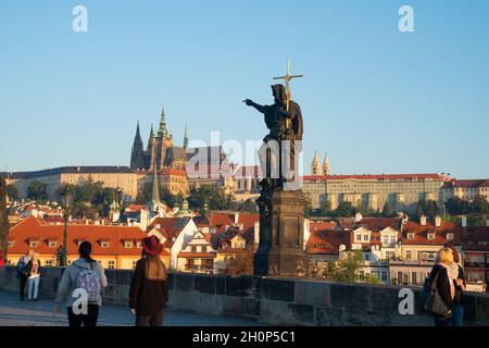 Prag, Tschechische Republik - 29 2017. August; Menschen und historische Statuen bei Sonnenaufgang auf der berühmten Karlsbrücke vor dem Hintergrund der Stadtarchitektur und St. Stockfoto