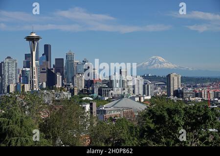 Seattle, WA / USA - 23. Juni 2021: Innenstadtgebäude und Mt. Rainier werden an einem Sommertag in einer weiten Ansicht gezeigt. Stockfoto