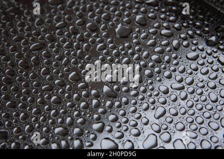 Wassertropfen regen Tropfen auf einem silbernen Metalltablett Stockfoto