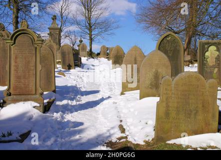 Schnee auf dem Friedhof der St. Michael and All Angels’ Church, wo der Vater der Bronte-Schwestern in Haworth, West Yorkshire, England, Minister war Stockfoto