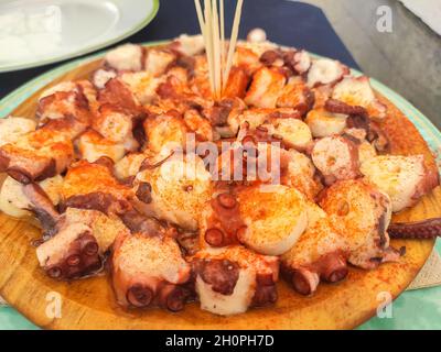 Traditionelle 'Pulpo a la Gallega'. Gekochter Oktopus auf Holzplatte, typisch galizische spanische Tapas Stockfoto