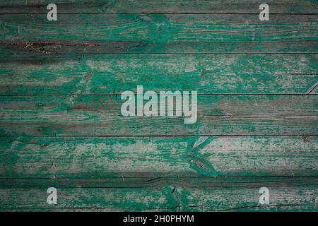 Holzstämme eines alten Hauses. Nahaufnahme. Verwitterte grüne Holzstruktur. Hintergrund. Horizontales Foto. Stockfoto