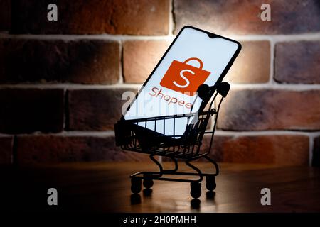 Shopee ist ein E-Commerce-Technologieunternehmen. Smartphone mit Shopee-Logo auf dem Bildschirm im Warenkorb. Stockfoto