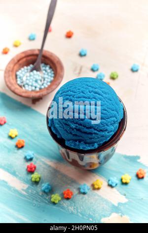 Hoher Winkel von leckeren blauen Gelato Schaufel zwischen bunten Zucker bestreut in Form von Blumen Stockfoto