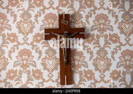 Heiliges Kreuz, Kruzifix an einer Wand, auf einer Vintage-Tapete Stockfoto