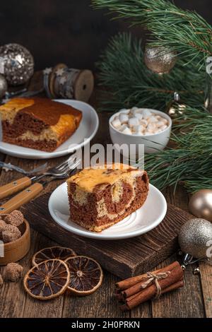 Ein Stück Kuchen auf festlichem Hintergrund mit Kiefernzweigen. Stockfoto