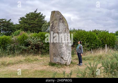 Frau neben dem Menhir von Kermaillard bei Sarzeau, Bretagne, Frankreich | Frau neben Kermaillard Menhir bei Sarzeau, Bretagne, Frankreich Stockfoto