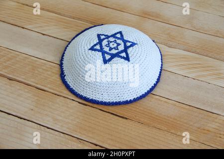 Jüdischer Kippahhut mit Davidstern auf dem hölzernen Hintergrund Stockfoto